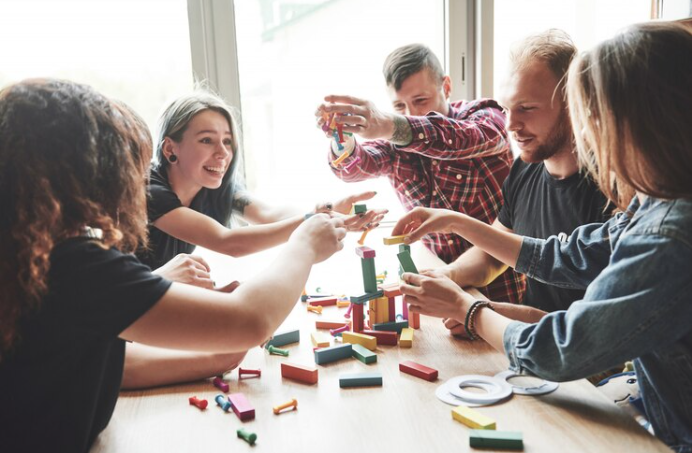 Grupo de adultos jogando um jogo de peças em uma mesa