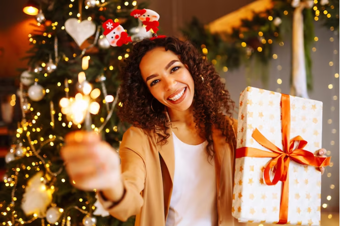 Mulher comemorando natal com presente nas mãos