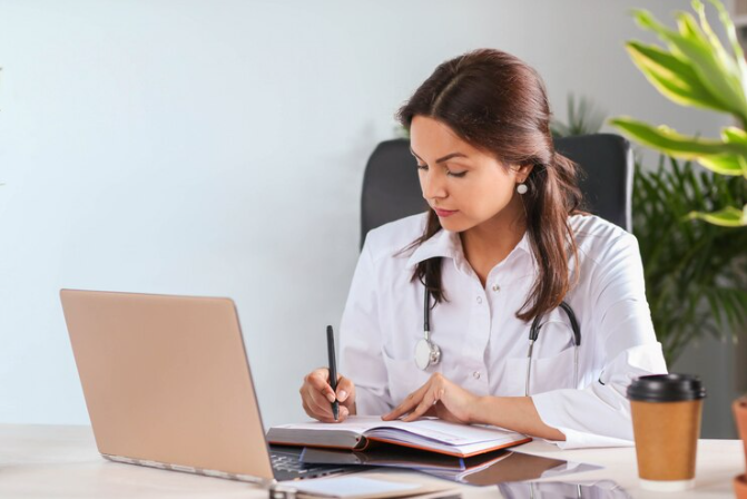 Médica estudando inglês frente ao computador